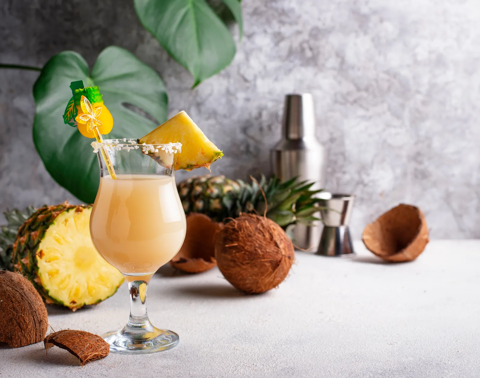 Classic pina colada with a pineapple wedge and cherry garnish beside fresh pineapple