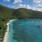 Green hills and a turquoise bay with sailboats on St. John, near St John restaurants on the north shore